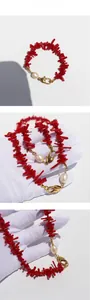 Detailed macro of red branch coral and pearl necklace with golden heart clasp