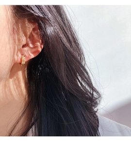 Close-up of 24k gold plated brass hoop earring with three inlaid cubic zirconia stones