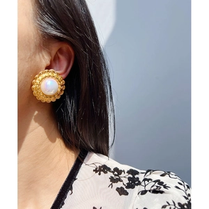 Orecchini vintage a girasole con filigrana dorata e perla iridescente sulla modella