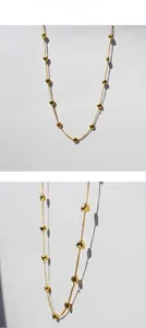 Detail presentation of a minimalist gold thin chain necklace with polished 3D heart beads