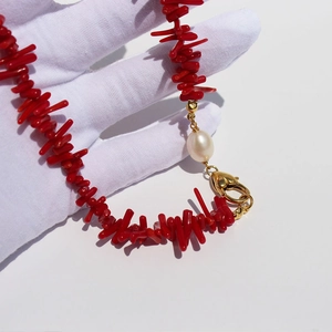 Handmade necklace with irregular red coral beads and a teardrop freshwater pearl detail
