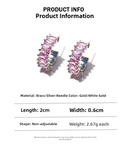 Detail showing C-shaped earrings with pink zircon inlay in gold and silver plating