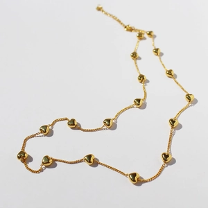 Polished gold heart charm necklace with multiple small 3D heart pendants on a fine chain