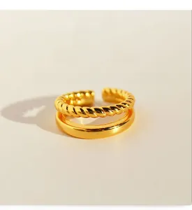 Close-up of double-layered gold-plated brass ring with twisted texture and zircon inlay