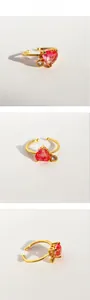 Detail of adjustable gold ring featuring pink heart gemstone and sparkling zircon charm