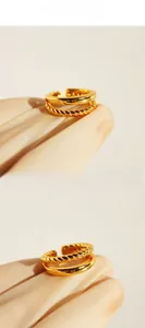 Detailed view of dual-layer brass ring featuring twisted rope and smooth gold plated bands