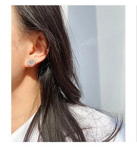 Close-up of a large single round zircon stud earring worn on a model's earlobe