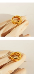 Close-up of a double-layered gold open ring with twisted rope texture and smooth band
