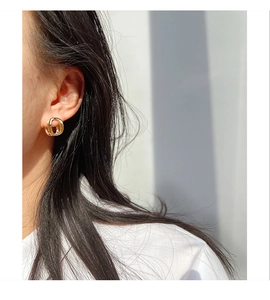 Close-up of elegant gold hollow geometric hoop earrings on a model with natural lighting