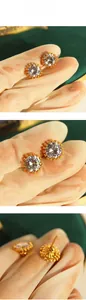 Detailed views of gold stud earrings featuring a large brilliant-cut zircon in claw setting
