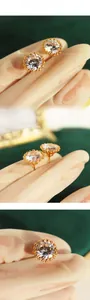 Detail presentation of golden sunflower stud earrings with round cubic zirconia center