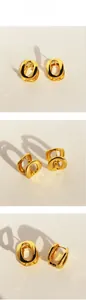 Macro view of geometric oval gold earrings with a polished mirror finish and drop shadows
