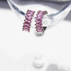 Elegant silver C-shape hoop earrings featuring pink baguette-cut zircons on a glass rim