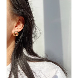 Minimalist brass gold-plated geometric hollow double-loop earring worn by a model