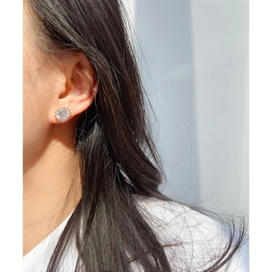 Elegant gold round stud earring with a central sparkling zircon on a female model
