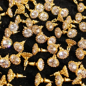 Sparkling gold stud earrings with large round cubic zirconia in petal setting on black velvet