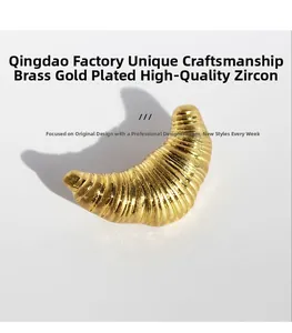 Macro detail of gold-plated brass croissant brooch with fine texture and zircon