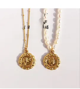 Detail of vintage gold-plated necklaces with angel coin and freshwater pearls