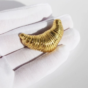 Polished gold croissant brooch featuring creative spiral texture for elegant styling
