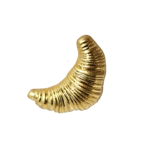 Glossy golden croissant shaped brooch with fine ribbed texture and metallic finish