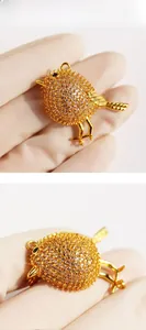 Detailed close-up of golden bird brooch pendant encrusted with sparkling cubic zirconia