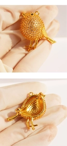 Macro detail of bird brooch pendant with pavé zircons and dual-purpose pin back