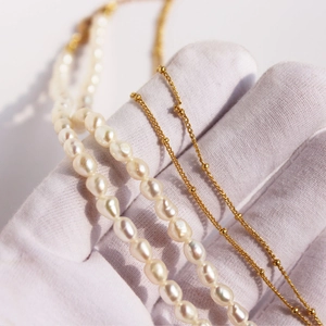 Double-layered necklace set featuring a vintage medallion and white freshwater pearls