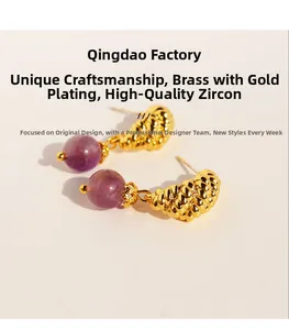 Macro detail of gold-plated twisted brass earrings with purple zircon beads