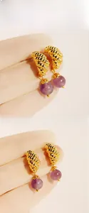 Detailed view of golden croissant hoop earrings featuring round purple agate stone drops