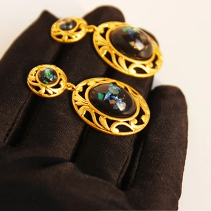 Vintage gold hollow lace earrings with black oval stones and shimmering gold foil details