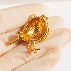 Golden bird brooch with cubic zirconia showing its high-quality hollow back structure
