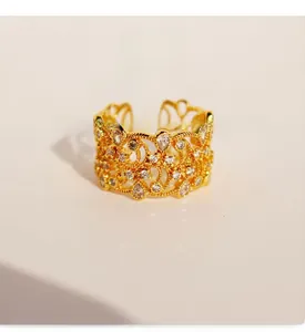 Détail de bague motif dentelle vintage en laiton doré ornée d'un zircon en goutte d'eau