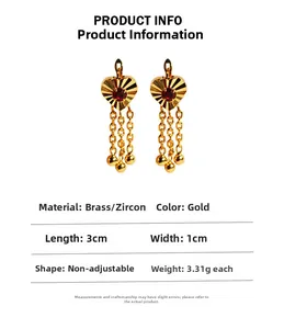 Detail of heart stud earrings with red zircon and golden ball chain tassels