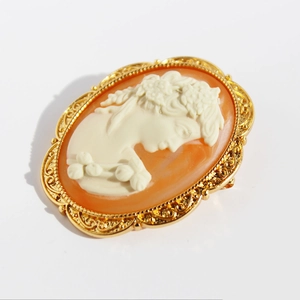Vintage oval cameo brooch pendant featuring ivory female relief with golden filigree frame