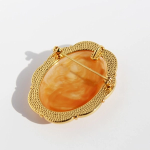 Vintage relief cameo brooch and necklace pendant in gold finish with orange stone texture
