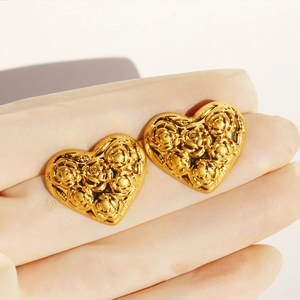 Orecchini a cuore vintage con rilievo a rosa in finitura oro mostrati sulla mano