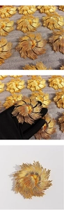 Macro detail of vintage gold-plated floral brooch with textured brushed metal petals