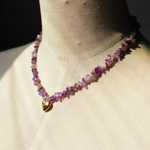 Collana con ametista irregolare e ciondolo a cuore dorato con zircone su modella