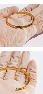 Gros plan sur le bracelet jonc en laiton doré aux détails de texture d'os de serpent