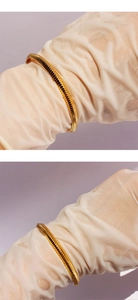 Gros plan sur le bracelet serpent doré montrant les maillons texturés et le fini brillant