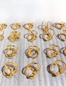 Macro view of minimalist knotted irregular line rings with polished golden plating