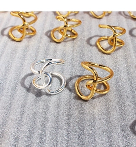 Close-up of high-polished irregular knotted rings in shiny gold and silver finishes