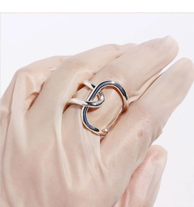 Macro shot of silver knot ring with irregular twisted lines on a white background