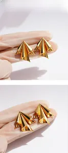 Detailed macro view of irregular gold metallic textured earrings with brushed silk finish