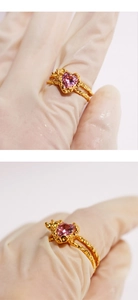 Macro detail of heart-shaped pink zircon ring with golden lava texture band