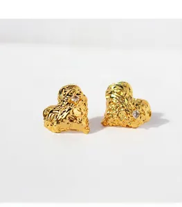 Detail of molten lava textured gold heart earrings with sparkling cubic zirconia stone