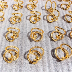 Minimalist minimalist irregular twisted gold knot rings in a multi-layered stacked design