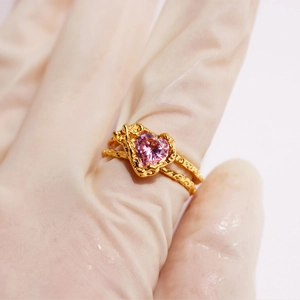 Golden double-band ring with a pink heart gemstone and textured hammer finish