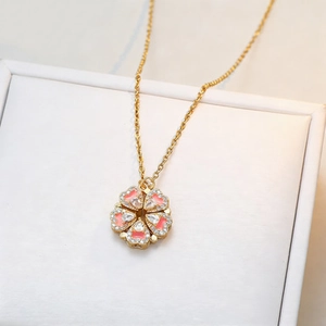 Golden heart necklace with pink crystals showing 4-leaf clover folding pendant design