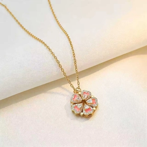 Chic gold clover necklace with pink heart petals and micro-pave crystals on fabric